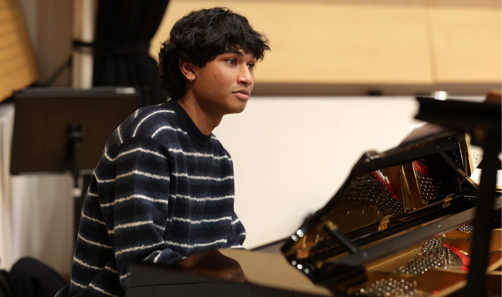 Photo of piano student at a grand piano.