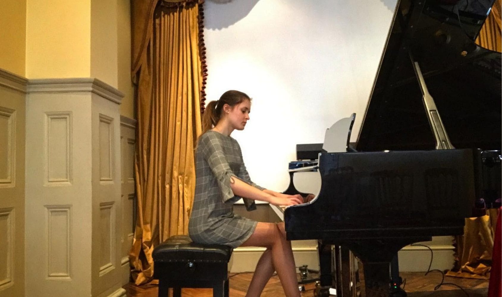 Nina at a grand piano.