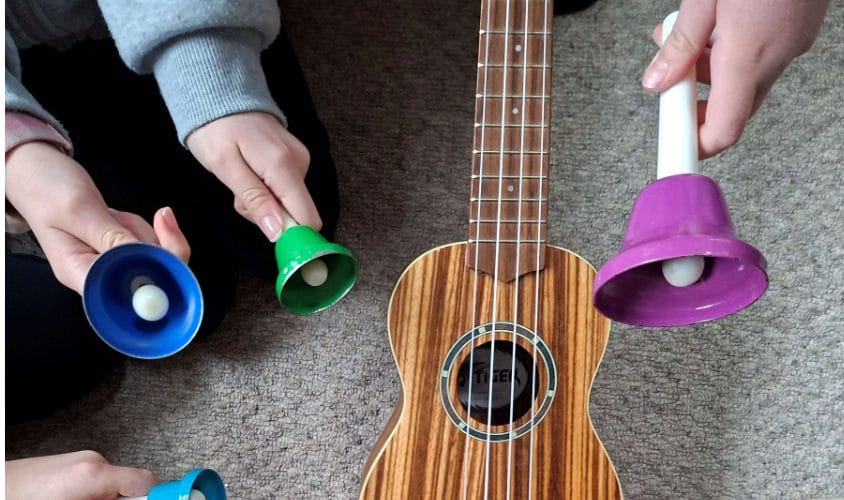 Close up shot of children playing bells.