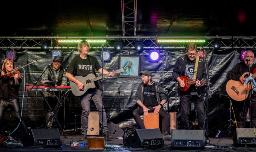 A five piece band playing on stage.